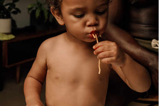 Toddler boy eating spaghetti